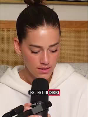 The cover image shows a woman with dark hair in a bun, looking down and speaking into a microphone. She is wearing a white hoodie. The overlay text reads 'OBEDIENT TO CHRIST'. The background is a wooden paneled surface and a cream colored cushioned surface.