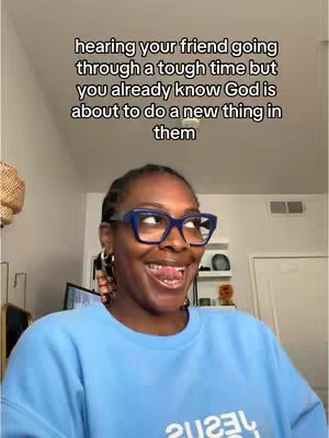 A woman in a blue sweater and blue-rimmed glasses is in the center of the frame, smiling with her tongue out. Overlaid above her is text that states she knows her friend is going through a tough time, but God will create something new in them,
