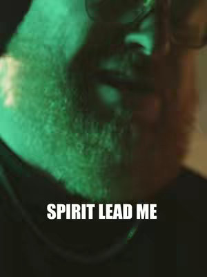 Close-up shot of a man's face, partially obscured by shadow and a green hue. "Spirit Lead Me" is written with white text toward the bottom.
