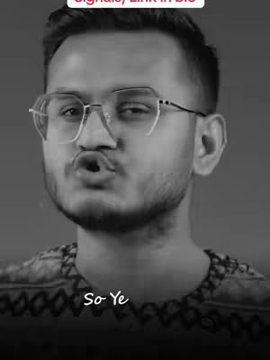 A grayscale image of a man with short dark hair, wearing glasses, and making a kissing face.
