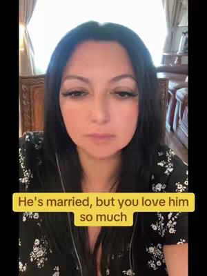 A woman with long black hair and heavy eye makeup looks down with a serious expression. A yellow box at the bottom contains the text 'He's married, but you love him so much.' The background suggests an indoor setting with curtains and furniture.