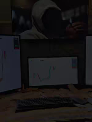 The image displays a setup of multiple computer monitors with trading charts. In the background, a person wearing a hoodie is partially visible, apparently watching the monitors, giving the impression of a trading or finance-related video setup.
