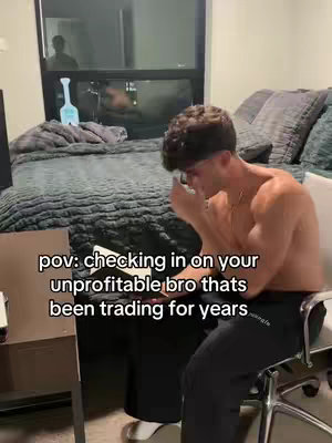 A man, shirtless, sits on a chair and covers his face with one hand. He is in a room with a bed visible in the background and a window. Text is overlayed in the image.