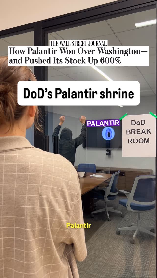 A person is seen from the back, standing in front of a glass wall separating them from a room. Inside the room, a person in a hoodie is raising their arms towards a screen with the Palantir logo and an eye symbol on it. Text overlays include "DoD's Palantir shrine" and "Palantir".