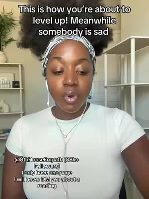 A medium shot shows a Black woman with a headband and curly hair, speaking into a phone or camera. Text overlays at the top explain the video's theme, while the bottom text reveals the creator's social profile and business details. The background suggests a cozy home setting with a bookshelf.