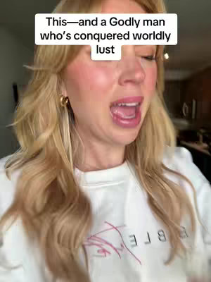 A blonde woman with long wavy hair is shown in a selfie-style video. She is wearing a white sweater and gold hoop earrings. Her mouth is open, and she appears to be speaking or reacting to something. There is a text overlay at the top of the frame.