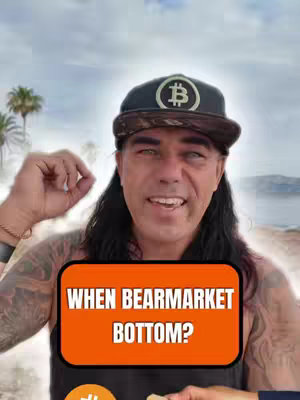 A man wearing a Bitcoin hat and a black top, posing in front of what appears to be a landscape. He has long black hair and a tattoo on his left arm and is holding up a hand with fingers extended. An orange rectangle with white text is overlaid on the image.