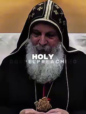 The image features a close-up of a man in religious attire. The man has a beard and is wearing a black robe with a hood and a decorative cross pendant. Text overlays are added.