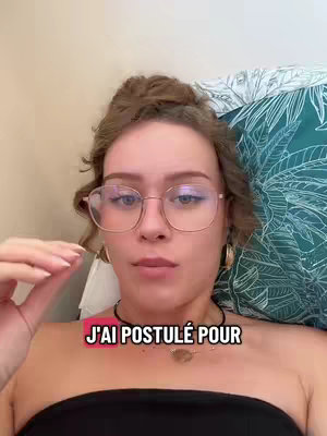 A selfie-style shot features a woman with styled, light-brown hair, wearing glasses and a black top, positioned as if she's reclining. The text overlay reads ''J'AI POSTULÉ POUR''.