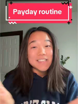 A woman is centered in the shot, looking towards the camera and smiling. Behind her is a door and a wall. Above her the text "Payday routine" is written in white font, set against a red background, with a white and black frame.