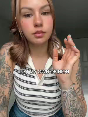 A woman with light brown hair and a light-colored top with a white and black horizontal striped pattern stands in front of a plain background. The text 'JUST MY OWN OPINION' overlays the image in a rectangular box.