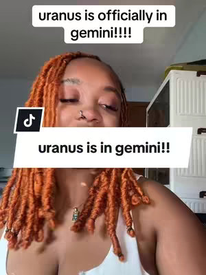 The image shows a woman with orange-red dreadlocks against a blurry background with a white cabinet. The overlay includes two text boxes: The top says "uranus is officially in gemini!!!!" and on the bottom reads, "uranus is in gemini!!" with a TikTok logo overlaid on the left.