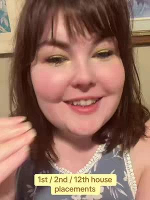 A close-up shot of a woman smiling, with a text overlay at the bottom. She has shoulder-length brown hair with bangs, and is wearing makeup. The background is slightly out of focus, but appears to be an indoor setting. The text overlay is on a yellow background.