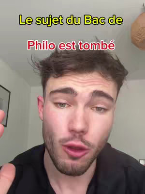 A young man with short brown hair is centered in the frame, gazing directly at the camera with a slightly open mouth, as if mid-sentence. He's wearing a dark black shirt, and the background is soft with a blurry view of a room. Overlayed on top, bold, large text in multiple colors adds visual interest to the image.