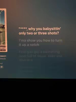 The cover features an album cover on the left side and song lyrics on the right. The text is white and overlaid on a dark, possibly blurred image background.