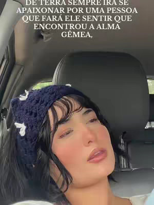 A woman is pictured inside a car, with the focus on her face. She has dark hair with bangs, a blue crocheted headband with white floral accents, and a slight smile. The car's interior, including a headrest, is visible behind her, and text appears above her head.