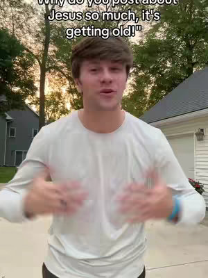 A young man stands outdoors in front of a house, speaking to the camera. Text overlays appear above his head. He is wearing a light-colored long-sleeve shirt and has a blue bracelet on his wrist.