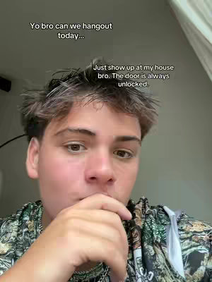 A young man with light skin and messy brown hair is shown from the chest up.  He's wearing a patterned shirt and is holding his hand up to his mouth, as if in thought.  Text overlays the image in a speech bubble.