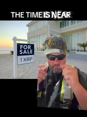 The image features a man with a camouflaged hat and sunglasses pointing towards the viewer while standing in front of a beachfront house. A sign that says 'FOR SALE 1 XRP' is planted in the sand.  Above the sign, text reads, 'THE TIME IS NEAR'.
