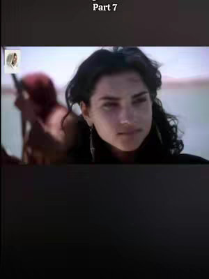 The cover image features a woman with dark hair and a focused expression. A slightly blurred figure in a red garment is behind her. The background is a hazy, light-colored environment, suggesting an outdoor setting. The video is shot in a dark mode.