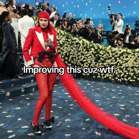 The image captures a person at an event, likely the Met Gala, wearing a striking red outfit. The outfit includes a red jacket with a white collar, red pants, and matching red leggings and shoes. A long red train trails behind the person, and the background shows multiple people and cameras. The text overlay, "Improving this cuz wtf.", suggests the person's look is being critiqued or reworked. The overall composition is vivid, with strong red tones against a backdrop of blurred figures and floral arrangements.