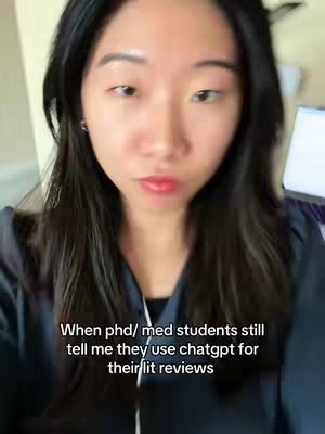 A selfie-style cover image featuring a fair-skinned woman with long, dark hair. She is looking directly at the camera with a neutral expression. The top part of her outfit is visible, a dark color. The background is blurred, but appears to be a neutral colored room. Text overlayed on the image states, "When phd/ med students still tell me they use chatgpt for their lit reviews."