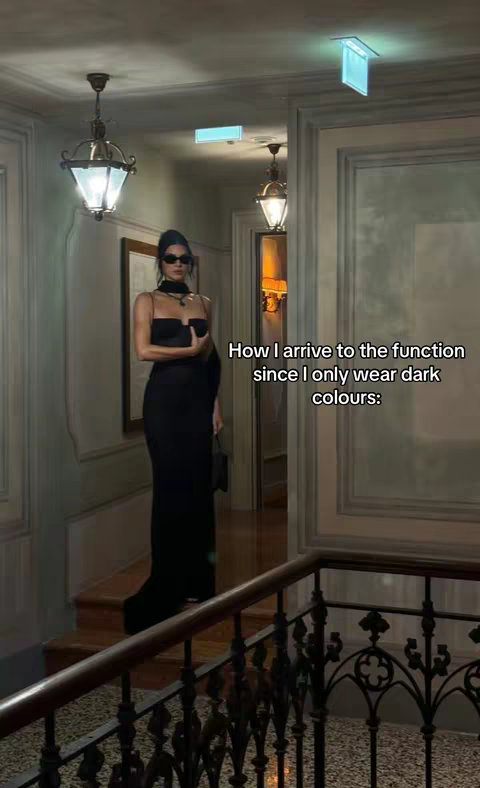 The image shows a woman, presumably Kendall Jenner, wearing a black dress and sunglasses in a stairwell with ornate railings and classic lighting fixtures. Text overlay suggests it is related to her fashion style.