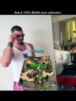A man in a white tank top and sunglasses poses with a pair of camouflage shorts. The shorts are the focal point, with price tags and text overlays indicating their value. The background includes a room interior.