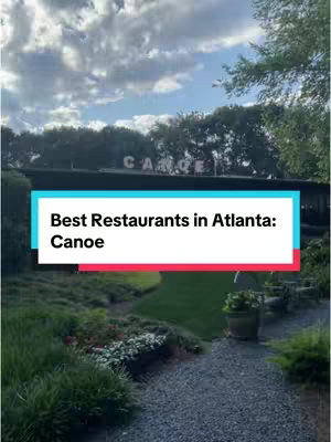 The image shows a restaurant exterior with a green lawn and a path leading towards the entrance. Text overlay reads "Best Restaurants in Atlanta: Canoe". The atmosphere is overcast and the scene suggests an outdoor restaurant setting.