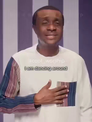 A man in a white shirt with a striped accent on the left sleeve stands against a striped purple and white backdrop. Text overlay reads 'I am dancing around'. The man has his right hand over his heart.