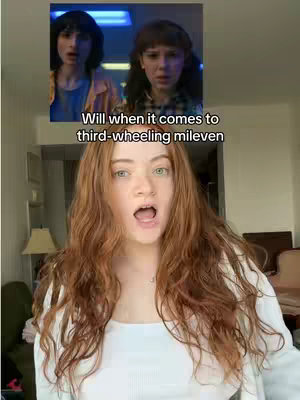 The video cover image features a young woman with red hair and an open mouth in the foreground. Above her, a split screen shows images of two characters, a male and a female, from the Stranger Things TV series. Text is overlaid on the split screen that reads, 'Will when it comes to third-wheeling mileven'.