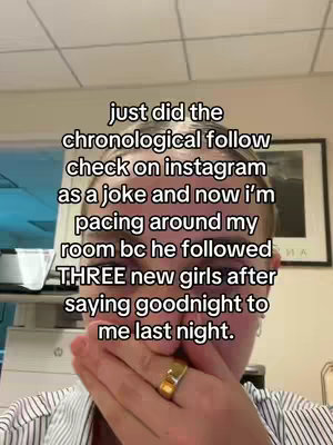 A selfie-style shot with text overlay and a person covering their mouth with their hand, suggesting surprise. The background includes an office-like setting with a framed picture, suggesting candid or personal video content.