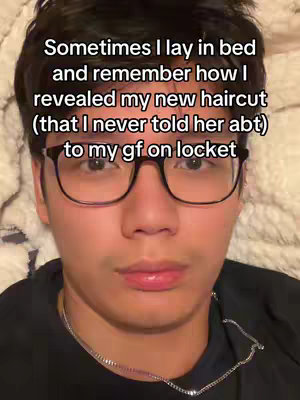 The cover image features a close-up of a young man lying in bed. He is wearing glasses and a black shirt, with a silver chain visible around his neck. The background is a beige blanket. The image is well-lit and focuses on his face.