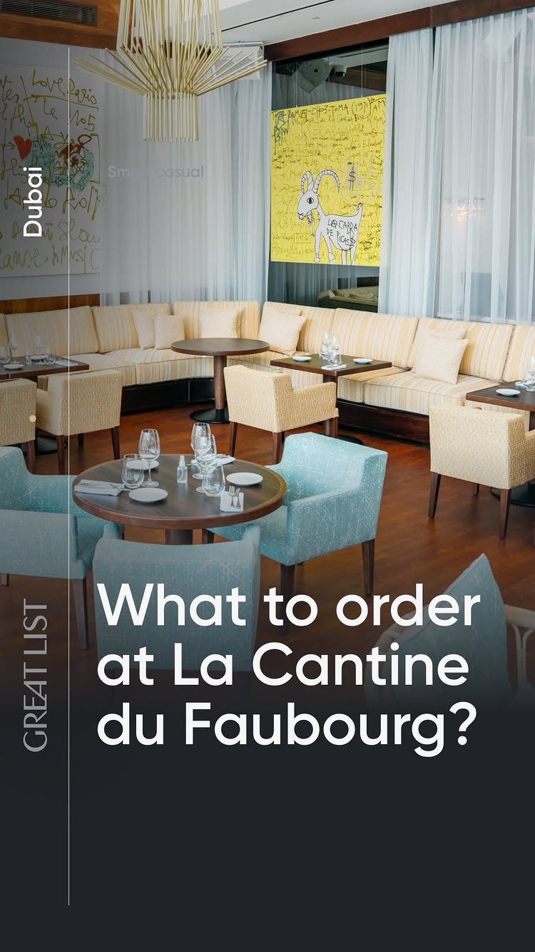 The image shows a restaurant interior with tables set for dining. The setting is modern and stylish, with a mix of booth seating and chairs. The color palette is neutral with light wood and cream-colored accents. Text is overlaid on a dark bar with the logo "GREAT LIST" and the question "What to order at La Cantine du Faubourg?".