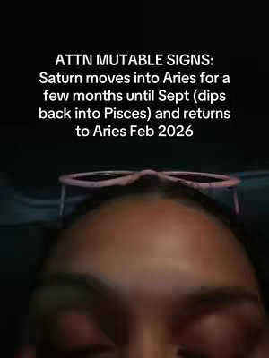 A selfie-style video cover featuring a person's face, with the top of their head and face making up the lower portion of the frame. Above them, extending across the top, are the frames of glasses. The background is dark. Overlay text in white is positioned at the top, and is about astrology.