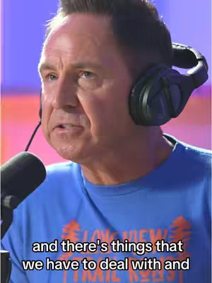 A man wearing headphones and a blue shirt is speaking into a microphone. The background has a pink and purple gradient. Text overlay at the bottom.