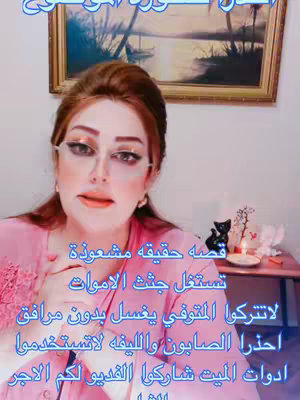 The cover image features a woman with long auburn hair and full makeup in a pink top, who is facing the camera with a serious expression. Behind her is a framed artwork depicting a scenic landscape. The background reveals a small table with decorations like a black cat figurine, candles, and flowers.