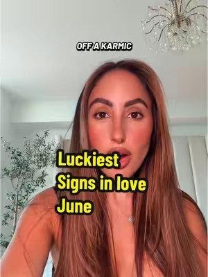A woman with long brown hair and fair skin looks directly at the camera with a slightly open mouth, as if speaking. Text overlays read 'OFF A KARMIC' at the top and 'Luckiest Signs in love June' in the middle. The background is a softly lit room with a chandelier visible in the top right corner.