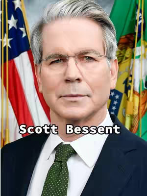 The image is a portrait of a man in a suit with a tie. The man is fair-skinned, has gray hair, and wears glasses. His face is centered in the frame. A text overlay at the bottom reads "Scott Bessent". Background includes parts of flags.