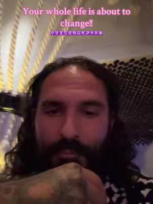 A man with long hair and a full beard is looking at the camera up close with text overlayed at the top of the image.