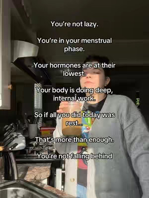 A person holding a clear cup of golden liquid, possibly a beverage, in a kitchen setting. Text overlays the image in clean, white font. The setting suggests a home environment, with glimpses of appliances creating a natural backdrop.