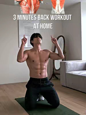 A man kneels on a green exercise mat, shirtless, with black pants, and white shoes, pointing upwards. Above the man are two anatomical illustrations of the human back, and a text overlay reads, "3 MINUTES BACK WORKOUT AT HOME". The background features a room with cream walls, a mirror, a sofa, and a wooden floor.