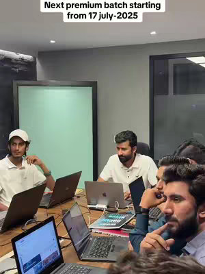 The image showcases a group of men seated around a conference table, each with a laptop. The setting is an office environment, suggested by the interior design and furniture. A text overlay at the top reads, 'Next premium batch starting from 17 july-2025'.