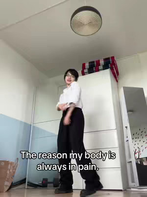 The image shows a woman in a room, dancing while wearing glasses and black pants. Text is overlaid on the bottom.