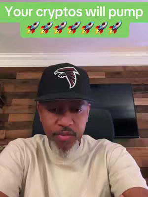 A man wearing a black cap with a white logo is facing the camera. The image is in a well-lit, home-like setting with a wooden textured wall and a television in the background. Text overlayed at the top says 'Your cryptos will pump' with rocket emojis.