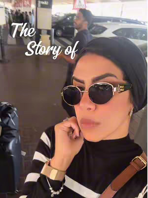 The cover image is a selfie-style shot in an outdoor setting, featuring a woman wearing sunglasses and a black head covering. She's in the foreground, with what appears to be a building and possibly a city street behind her. The text overlay reads 'The Story of,' in a clean white font at the top left corner. The woman is glancing slightly downward, and her hand is touching her jaw, and she is wearing a stylish top with black and white stripes.