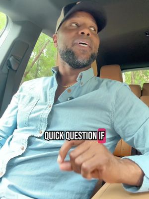 A man with a beard is leaning in the driver's seat of a car, looking upward and to the right of the camera. He is wearing a light blue button-down shirt and a baseball cap, and he has a gold chain around his neck. Overlay text at the bottom left says 'Quick Question If'.