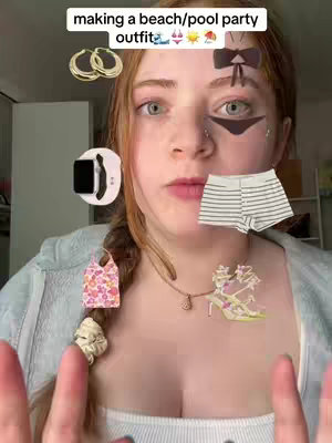 A young woman with fair skin and red hair is centered in a selfie-style shot. Her eyes are a light color, and her expression is neutral. Various accessory graphics, including bow and bikini-shaped items, are overlaid around her face. Below these, there’s a necklace and a few accessories. In front of her, items related to a beach or pool party outfit are arranged as if she is interacting with them.