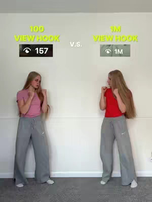 The image is a split comparison. On the left, a woman in a pink shirt and grey pants stands with fists up towards the camera. She faces the right and also has text on top that says '100 View Hook ' and beneath that are a number, '157', inside a rectangle showing a visible eye icon. On the right, another woman in a red shirt and the same gray pants stands, fists up toward the camera, and is facing towards the left. Text on top reads '1M View Hook ' and lower down, a number, '1M' inside a similar rectangle with a visible eye icon.