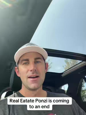 A man in a white baseball cap sits in the driver's seat of a car with a sunroof. The sky is visible through the sunroof. Text overlaid at the bottom of the image reads, 'Real Estate Ponzi is coming to an end.'